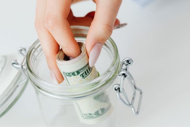 person puttin money in a jar