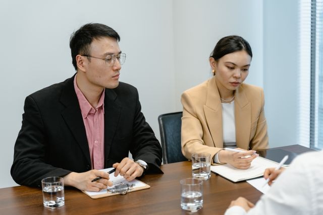 two people sitting in front of clipboards